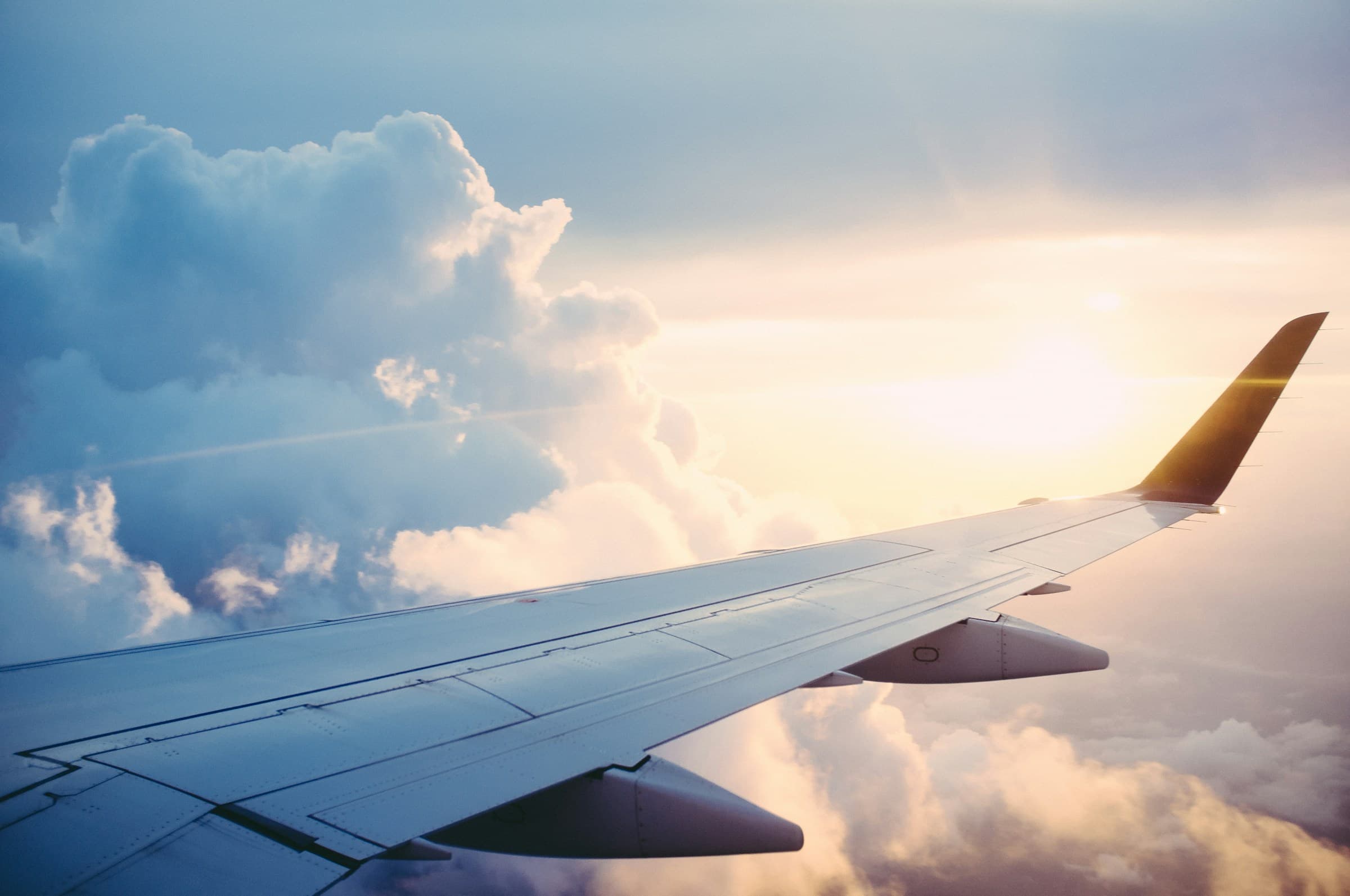 Aircraft wing above sunset clouds