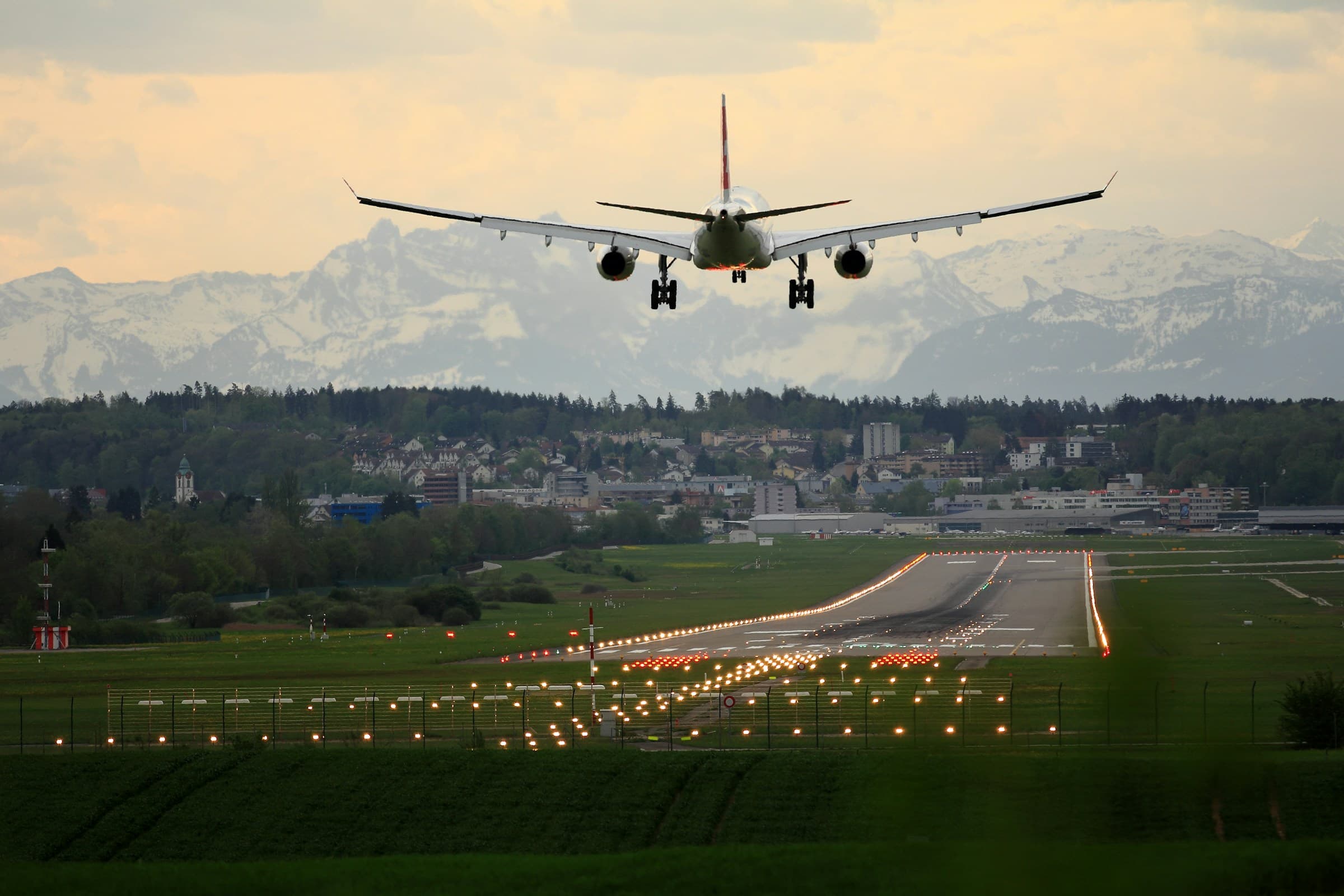 Aircraft on final approach over alpine landscape